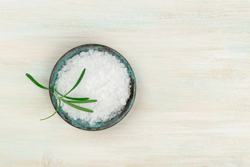 Rosemary infused sea salt, shot from above on a white wooden background with a place for text