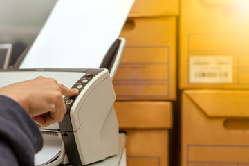Office staff are scanning documents, storing data into the computer, to reduce usage and reuse paper.