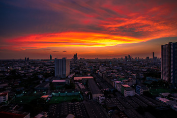Obraz premium Panorama background of city views, with colorful twilight sky, high-rise buildings (condominiums, offices, expressways) and blurred lights from roads and traffic.