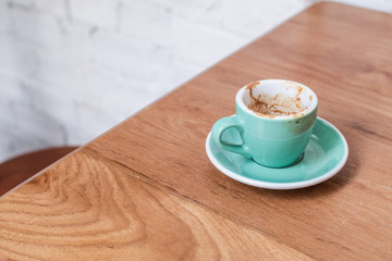Empty coffee cup after drink on wood table light,empty coffee have spoon beside on the desk ,have a Magazine can read in the morning,beautyful light