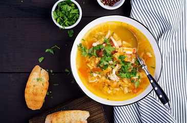 Red lentil soup with chicken meat and vegetables close-up on the table. Healthy food. Top view