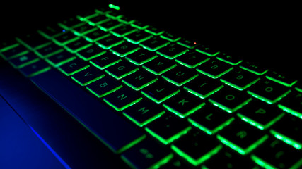 Gamer Keyboard with green and blue backlight, modern gaming computer.