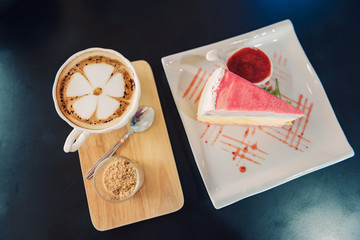 Latte arts coffee and crepe cake with strawberry sauce, top view