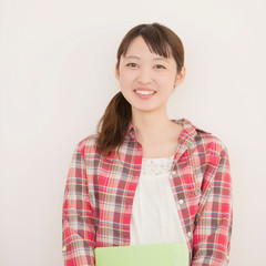 勉強道具を持ち微笑む大学生
