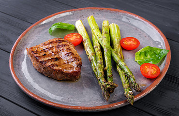 Barbecue grilled beef steak meat with asparagus and tomato.