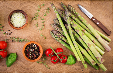 Fresh green asparagus on a rustic wooden table with copy space. Top view