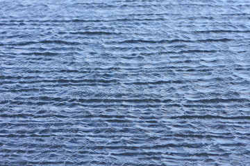 Pattern of steel blue sea surface with tiny choppy irregular waves.