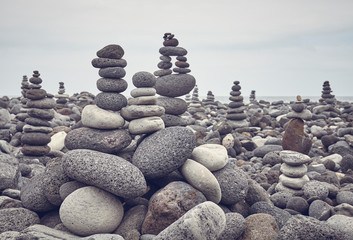 Stone stacks on a beach, color toning applied, selective focus.