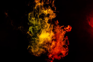 Obraz na płótnie Canvas Beautiful horizontal column of smoke in the neon bright light of red, green, yellow and orange on a black background exhaled out of the vape. Nice pattern for printing and backdrop of colored waves.