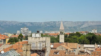 Scenic aerial view of the city from the bell tower, roofs of houses and church in old town, beautiful cityscape, sunny day, Split, Croatia