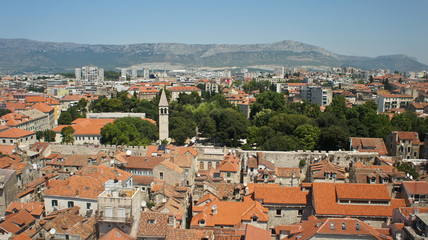 Fototapeta na wymiar Scenic top view of the city from the bell tower, roofs of houses and church in old town, beautiful cityscape, sunny day, Split, Croatia