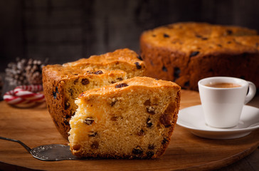 Slices of home made cake with raisins on wooden plate and coffee cup