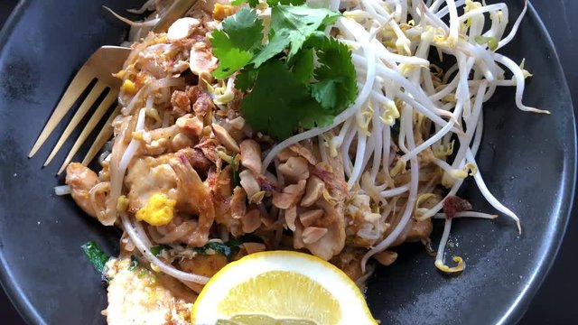 SLOW MOTION - Closeup gourmet asian patai wich chicken and lemon top down