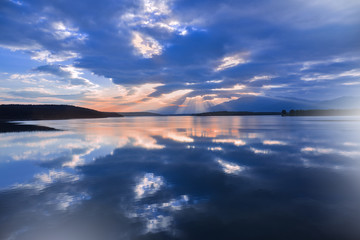 Fototapeta premium Incredibly beautiful sunset.Sun,sky,lake.Sunset or sunrise landscape, panorama of beautiful nature. Sky with amazing colorful clouds.Water reflections.Magic Artistic Wallpaper.Blue Background.Light.