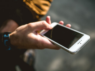 Man holding mobile phone in their hand