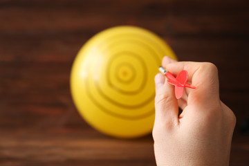 Darts player using balloon as dartboard, closeup