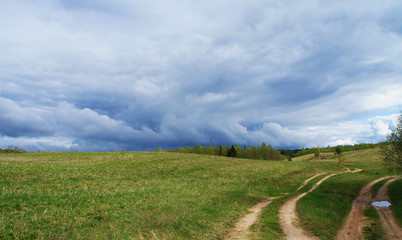 The sky is a thunderstorm contrasting clouds before the rain in the meadow in the field.