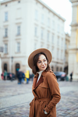 Fototapeta premium Portrait of young stylish hipster woman walking on the street, wearing cute trendy outfit