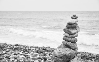 Black and white picture of a stone stack on a beach.