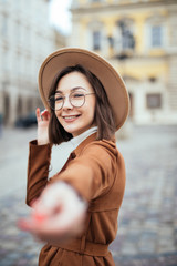 Happy young woman in stylish trendy clothes making her selfie in the street