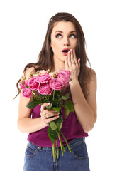 Surprised young woman with bouquet of flowers on white background