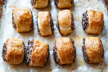 Crispy freshly baked cookies with poppy seeds on a baking tray.