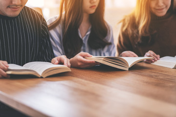 Group of people sitting and enjoyed reading book together on wooden table