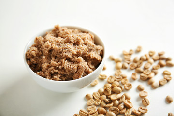 Bowl with coffee body scrub on white background