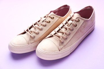 Pair of stylish casual shoes on color background