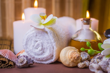 Fototapeta na wymiar Massage spa treatment image relaxation background burning candles with flowers and seashells