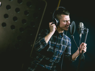 The young guy singing in recording studio