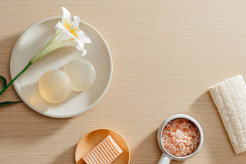 Top view of organic spa skincare products with salt, flowers, towels and rice soaps