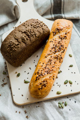 Freshly baked white and grey bread on dark grey fabric with seed