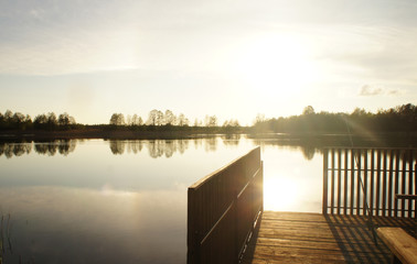 Fototapeta premium Old wooden arbor jetty on the lake at sunset.