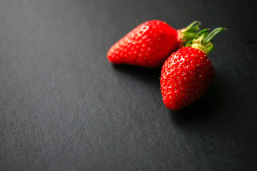 Two delicious strawberrys on black background