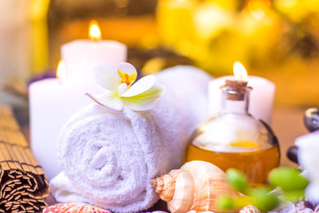 spa setting with burning candle and white flowers