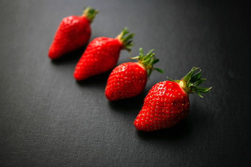 Four delicious strawberrys on black background