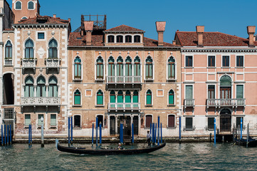 Fototapeta na wymiar Venice, Italy, April 1st, 2019 Canale Grande waterfront with gondola and residential houses