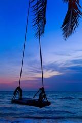 Swing on a tropical beach against the sun light.