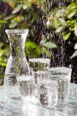 Glasses full of water for the refreshment on a hot summer day. Rain water on a table
