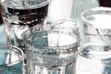 Glasses full of water for the refreshment on a hot summer day. Rain water on a table