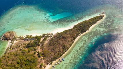 aerial view tropical island with sand white beach, palm trees. Malcapuya, Philippines, Palawan. Tropical landscape with blue lagoon, coral reef