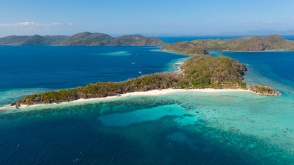 aerial seascape tourists enjoy the tropical beach. tropical island with sand beach, palm trees. Malcapuya, Philippines, Palawan. Tropical landscape with blue lagoon, coral reef