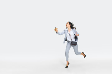 Please, wait. Young woman in gray suit comes late for work while trying to stop the bus on the run....