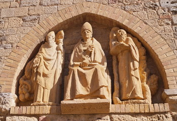 Bas-relief on the external wall of the cathedral of Volterra, Tuscany, Italy