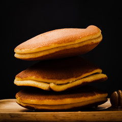Pancake with honey syrup and black background.