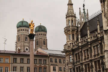 Fototapeta na wymiar Münchner Wahrzeichen / Mariensäule und Frauenkirche vom Marienplatz aus gesehen