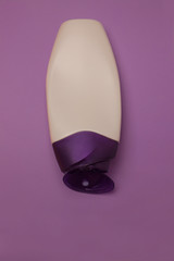 Beauty, decorative cosmetics bottles. Peach and purple colors background, flat lay, top view,...