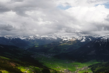 Fototapeta premium view in a valley from a mountain in the alps on a cloudly and dark day