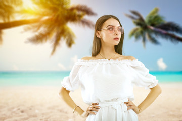 Slim young woman with sunglasses on beach with palms. Summer time 